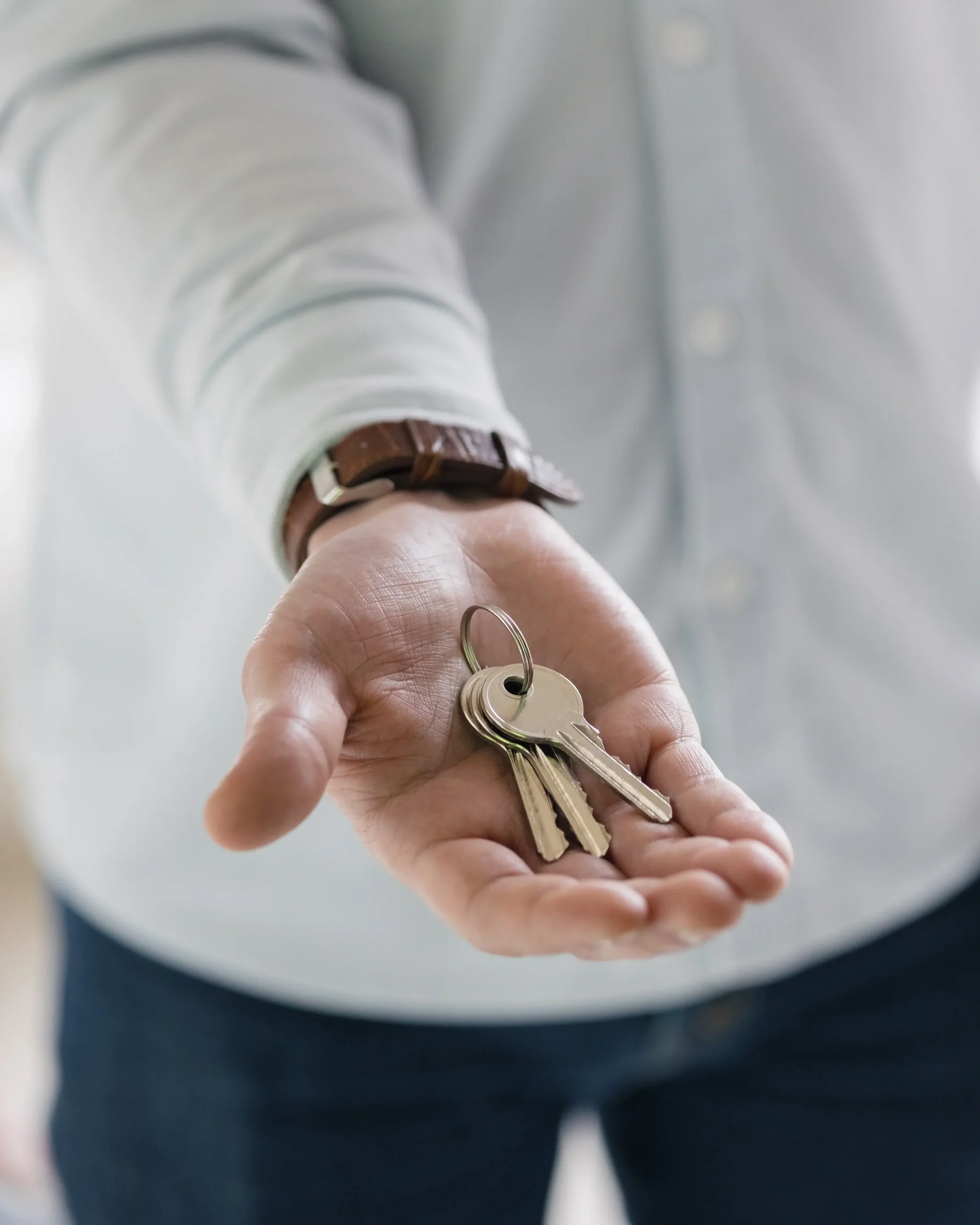 "Close-up of a locksmith holding a set of keys in an outstretched hand, symbolizing ready solutions and access.